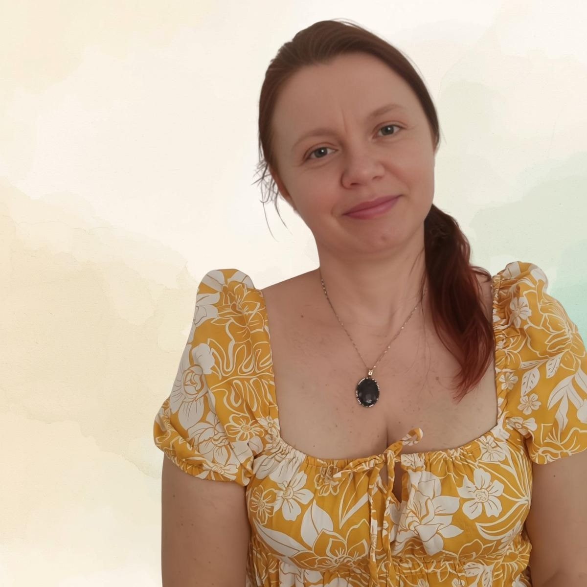 Svetlana Cainac con blusa floral y collar de piedra oscura